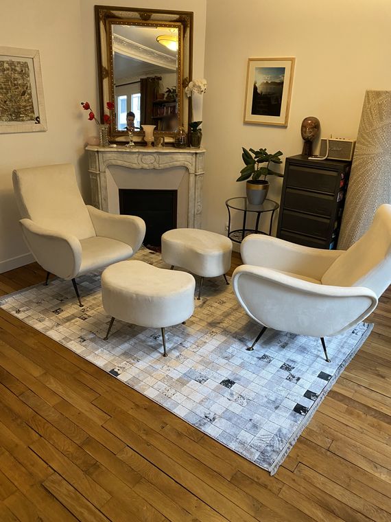 Turkish silk rug, an artist's design in grey and white, laid in a Parisian drawing room between two white armchairs, in front of a marble fireplace